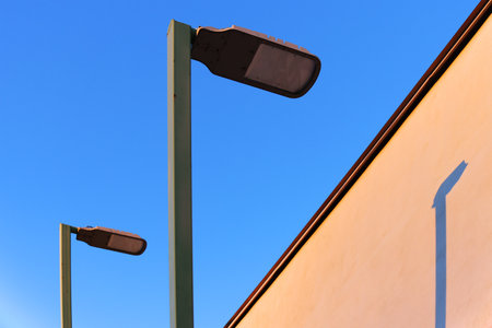 street lamps on the wall of a building against the blue sky.の写真素材