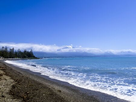 beach in New Zealand wih beautiful wave and mountain in backgroundの写真素材