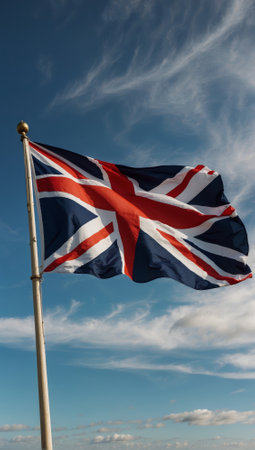 A British flag flies in the sky. The flag is blue, white and red. United Kingdomの素材
