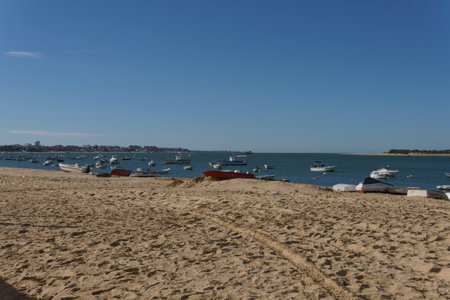 Sunny Day at Beach with Anchored Boats in Tranquil Seaの写真素材