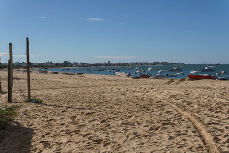 Sunny Day at Peaceful Beach with Anchored Boats in Distanceの写真素材