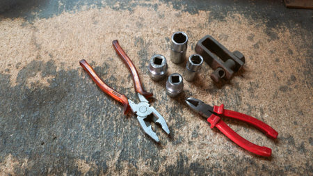 Combination pliers, diagonal cutting pliers and sockets resting on a workbench covered with sawdust and wood chipsの写真素材