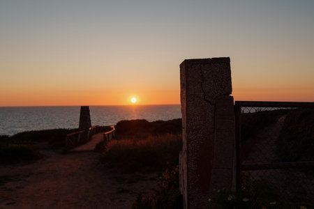 Sun setting over the sea, creating a scenic coastal view at duskの写真素材