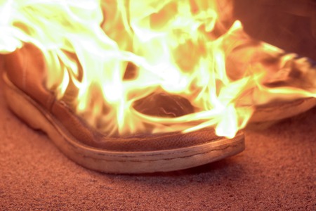 Burning boots on the sand at coast 4kの写真素材
