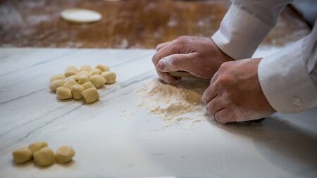 A taiwanese chef rolls out dough before filling it with meat to create jiaozi, a Chinese dumpling....