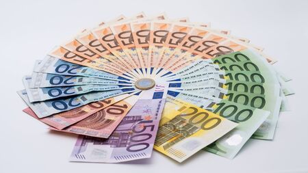 Closeup of a coin one euro with banknotes of different values. Cash money background. Real hundred euros. Good earnings. Issuing salary. Credit percent. Successful businessの写真素材