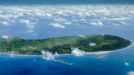Beautiful view of Netherlands coast from above, as seen through airplane window. Plane flying above beach of Amsterdam. Flight trip with green field and blue oceanの写真素材