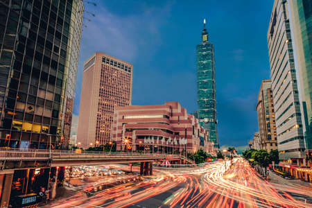 View of Taipei main road from day to night with the famous building 101 and traffic car light long exposure photo. Cityscape of street with traffic and pedestriansのeditorial素材