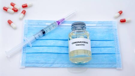 Sample for Covid 19 vaccination and syringe injection on protective surgical mask. Preventive medications for novel Coronavirus 2019-nCov concept. Corona virus danger and public health risk disease.の写真素材