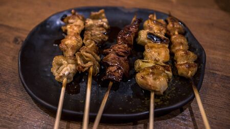 Pork skewers then grilled. Yakitori are a popular Japanese food in the izakaya restaurant. Japan skewer is a wood stick used to hold pieces of food together.の写真素材