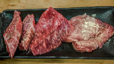 Thinly sliced Japanese wagyu beef on grille for barbecue. Grill one of the best beef in Japan. Style Yakiniku meaning grilled meat cuisine. BBQ food.の写真素材