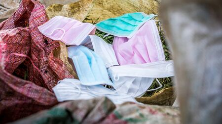 Protective mask discarded and thrown in the trash. Used surgical masks for protection the Covid-19....