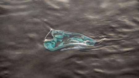 Coronavirus plastic waste polluting the environment. Disposable masks outbreak trash in the ocean....