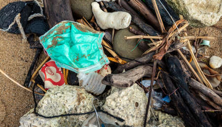 Garbage from used medical masks and gloves on the beach. Bad consequences like pollution or...