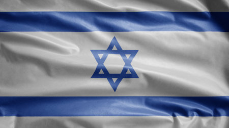 Israeli flag waving in the wind. Close up of Israel banner blowing, soft and smooth silk. Cloth fabric texture ensign background. Use it for national day and country occasions concept.の写真素材