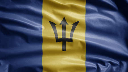 Barbadian flag waving in the wind. Close up of Barbados banner blowing, soft and smooth silk. Cloth fabric texture ensign background. Use it for national day and country occasions concept.の写真素材