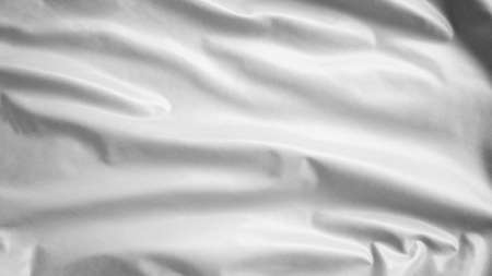 Empty white flag waving in the wind. Close up of symbol of surrender blowing, soft and smooth silk. Cloth fabric texture ensign background.の写真素材