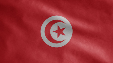 Tunisian flag waving in the wind. Close up of Tunisia banner blowing, soft and smooth silk. Cloth fabric texture ensign background. Use it for national day and country occasions concept.の写真素材