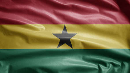 Ghanaian flag waving in the wind. Close up of Ghana banner blowing, soft and smooth silk. Cloth fabric texture ensign background. Use it for national day and country occasions concept.の写真素材