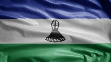 Lesotho flag waving in the wind. Close up of Sesotho banner blowing, soft and smooth silk. Cloth fabric texture ensign background.の写真素材