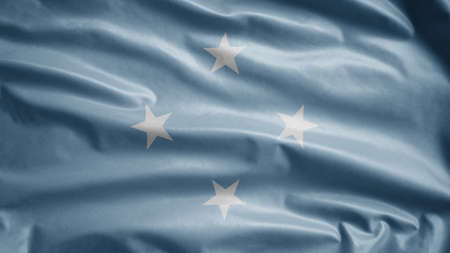 Micronesian flag waving in the wind. Close up of Micronesia banner blowing, soft and smooth silk. Cloth fabric texture ensign background.の写真素材