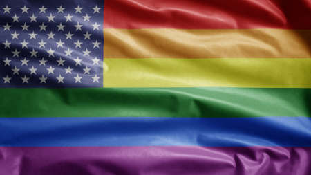 USA gay pride flag waving in the wind. Close up of United States LGBT community banner blowing, soft and smooth silk. Cloth fabric texture ensign background. Use for pride gay day and events concept.の写真素材