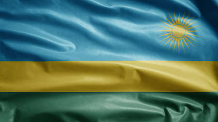 Rwandese flag waving in the wind. Close up of Rwanda banner blowing, soft and smooth silk. Cloth fabric texture ensign background. Use it for national day and country occasions concept.の写真素材