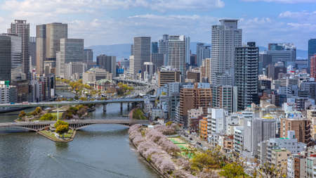 Aerial view of Osaka city and the river from sky building. Bird eye view of cityscape with crowded skyscrapers offices and apartments. Panorama urban rooftop view from the skyline at Japan districtのeditorial素材