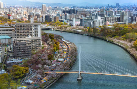 Aerial view of Osaka city and the river from sky building. Bird eye view of cityscape with crowded skyscrapers offices and apartments. Panorama urban rooftop view from the skyline at Japan districtのeditorial素材