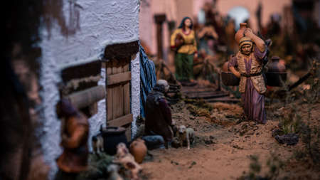 Typical decorative figures of traditional in Christmas of the portal of Belen. A close up photo of a beautiful landscape nativity scene of Spain with figure of people at streetの写真素材