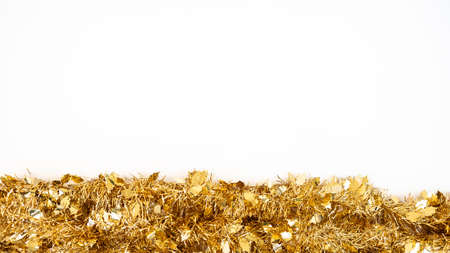 Christmas decoration isolated on white background. Golden tinsel Xmas ornaments with copy space for text. New year realistic decor ribbon garland. Design element for celebrate card or flyerの写真素材
