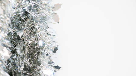 Christmas decoration isolated on white background. Silver tinsel Xmas ornaments with copy space for text. New year realistic decor ribbon garland. Design element for celebrate card or flyerの写真素材