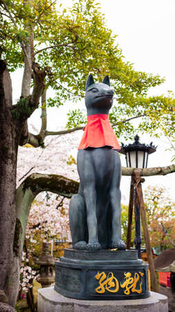 Kitsune japanese fox statue with red apron at famous Fushimi Inari-Taisha shrine near Kyoto. Japan god guard made of stone at Shinto shrineのeditorial素材