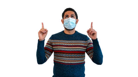 Caucasian man pointing with two hands and fingers to the top and using sterile face mask isolated on...