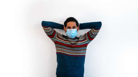 Caucasian man using sterile face mask isolated on white background studio. Guy at quarantine pandemic virus virus concept.の写真素材