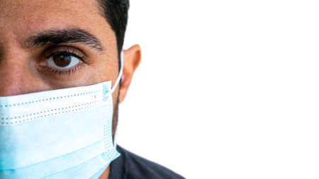 Portrait of caucasian man with a medical mask during virus outbreak. Person at indoor studio shot isolated on white backgroundの写真素材