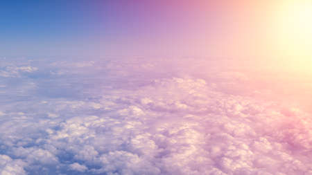 Aerial traveling. Wonderful view of the sky and clouds with the twilight from above, as seen through an airplane window. Morning mist. Flying at dusk or dawn. Fly through orange cloud and sun.の写真素材