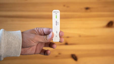 Close-up of man's hand holding a positive test device
