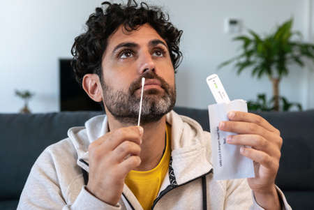 Portrait of relaxed man taking a self swabbing home testsの写真素材