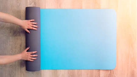 Elevate view female hands in sportswear doing yoga in the house indoor, healthy person meditation in...