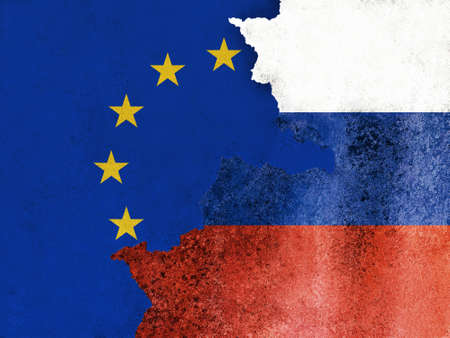 Flags of European Union and Russia on cracked cement of damaged wall texture, background. Europe banner with a long stone crack grunge in abandoned industrial building outside on Russian town street.の写真素材