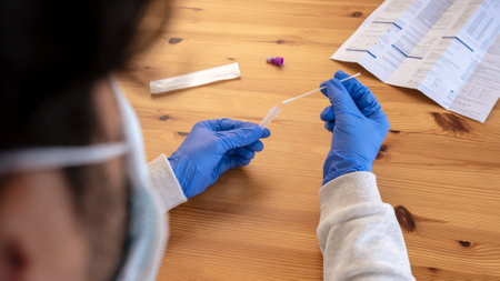 Caucasian man looking instructions for used an antigen diagnostic test device at home. Done tests in...