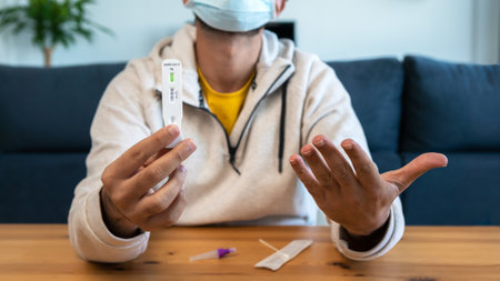 Caucasian man makes a rapid home test device for Covid19 virus with a positive result. Antigen...