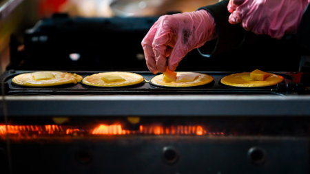 Japanese market, a street vendor engages in the art of crafting Dorayaki with cheeses, the beloved Asian snack. A woman creating delicious pancakes that captivate the senses. A popular snack in Japanの写真素材