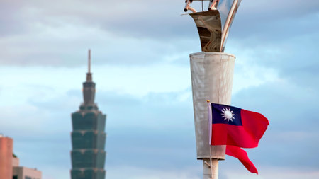 Taiwan flag waving in front of Taipei 101 during dusk, capturing a serene moment with the cityâ most iconic skyscraper in view.の写真素材