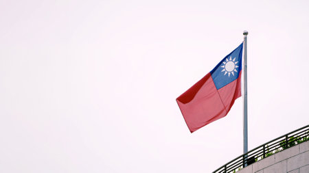Taiwan flag waving a top a modern building with empty copy space for text, reflecting unity, pride,...
