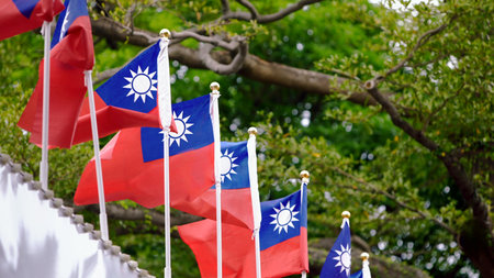 Taiwan flags waving with lush greenery in the background, representing national pride and connection to nature.の写真素材