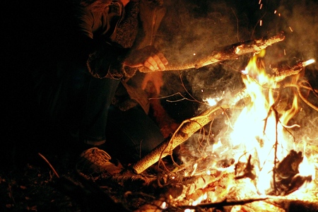 People sit at night round a bright bonfireの写真素材