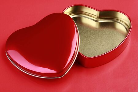 Empty Heart-shaped Tin on red background.の写真素材