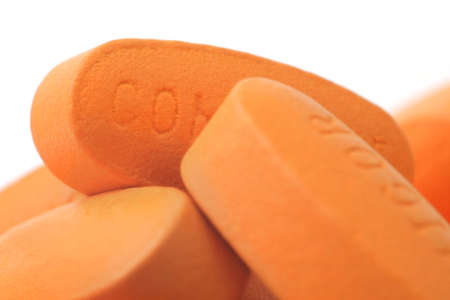 Pills on Spoon. White background. Orange Color.の写真素材